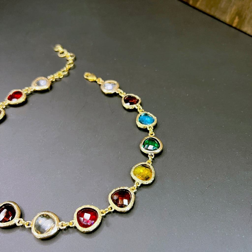 Close-up angle of the Idina rainbow crystal choker showing rich jewel tones and gold prong settings