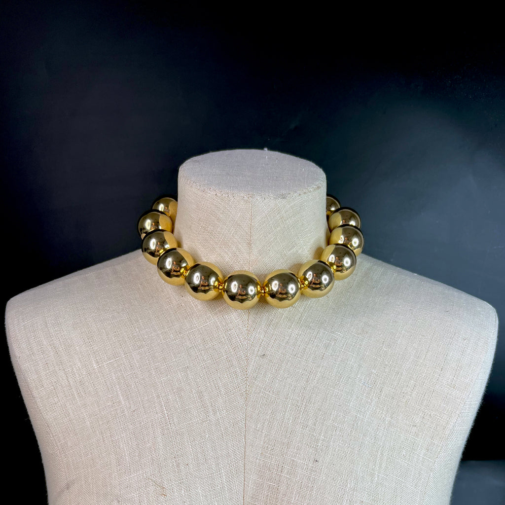 Fashion editorial look featuring oversized gold choker necklace – modern disco statement accessory