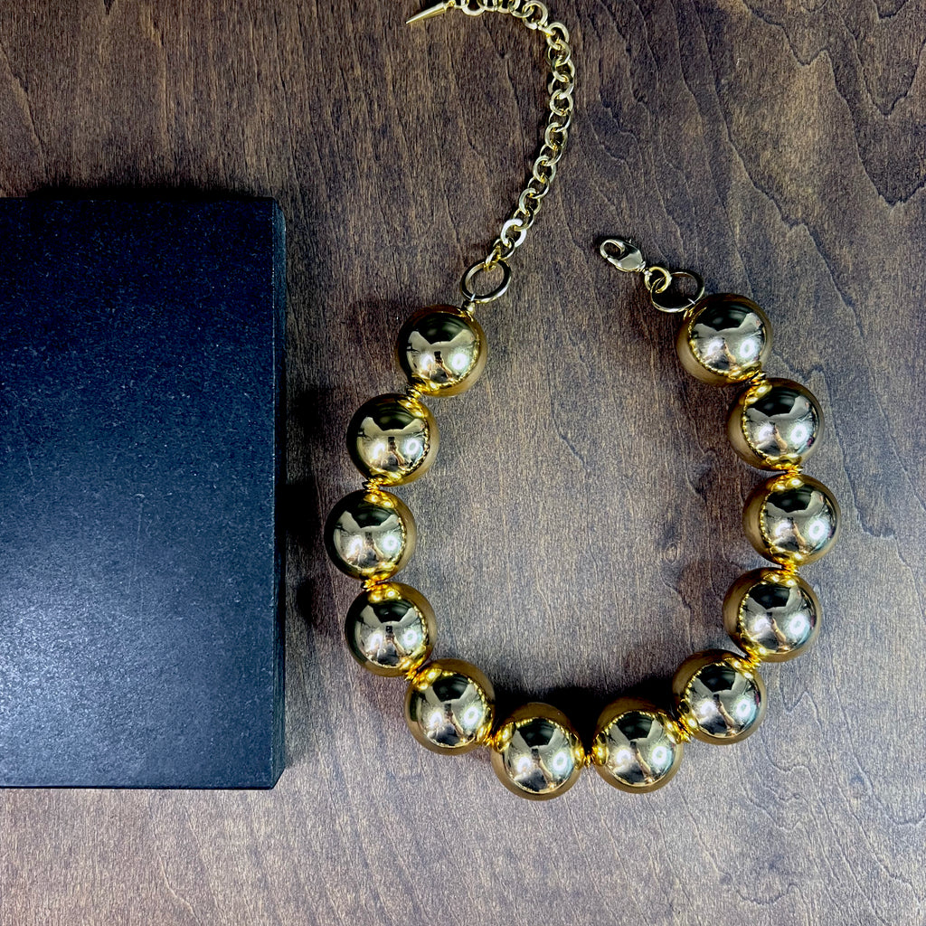 High-shine gold beaded choker necklace on model – sculptural accessory for elevated styling