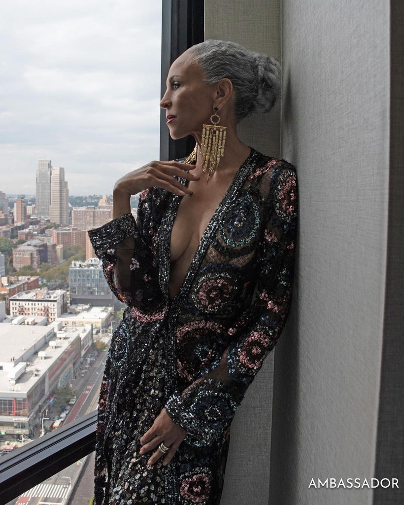 The Legendary Alva Chin in Crystal statement earrings with gold accents worn with swept-back hair – Lepuma chandelier earrings