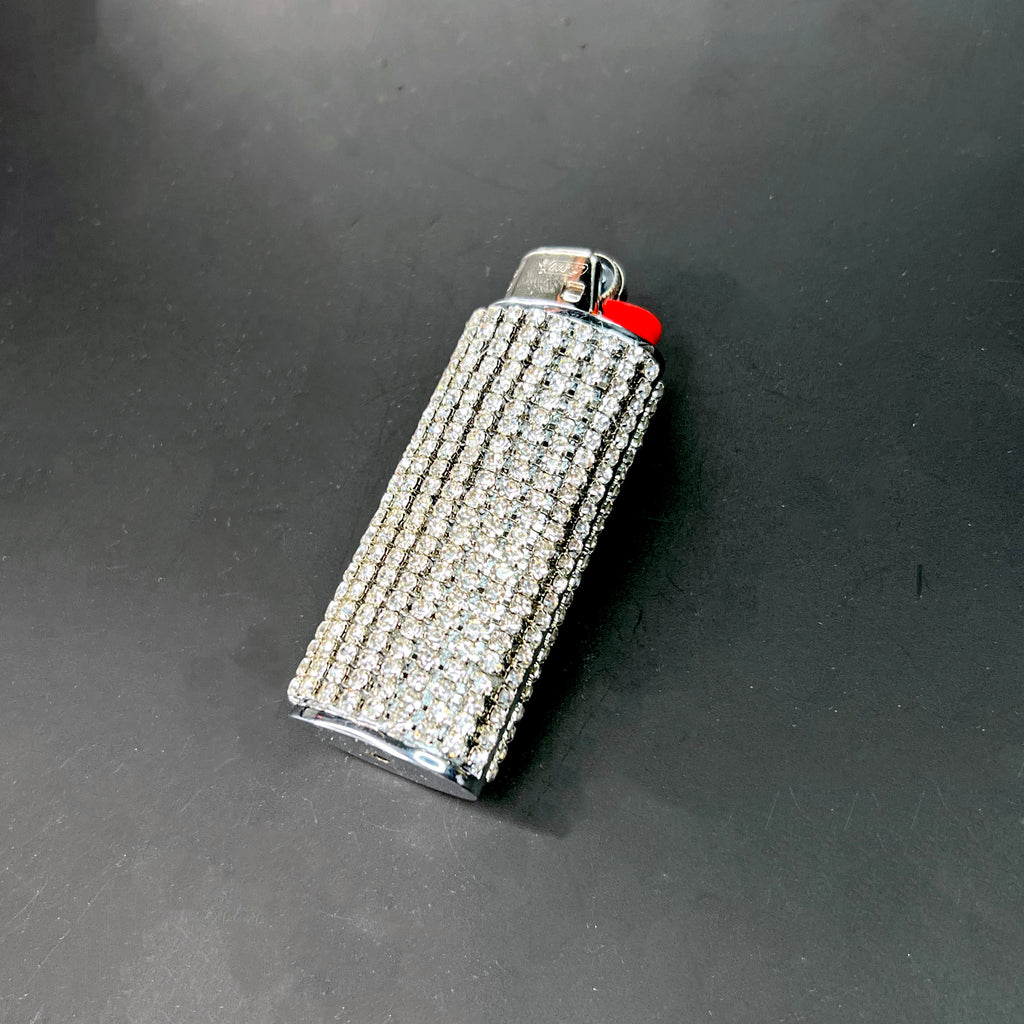 Fashionable bling crystal lighter case featuring rows of rhinestones against a black surface.