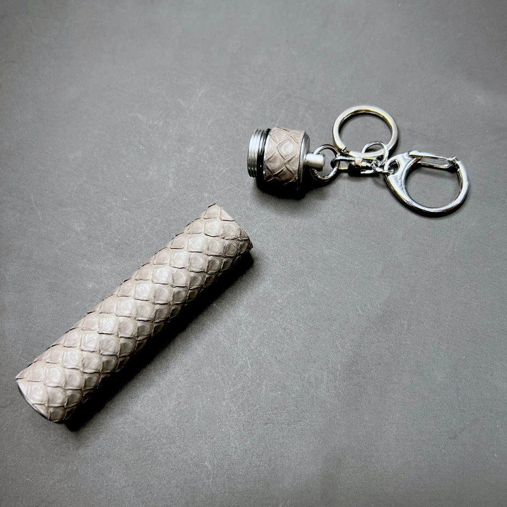 Luxury Storm Grey python wrapped pre-roll holder key charm laid flat on black background