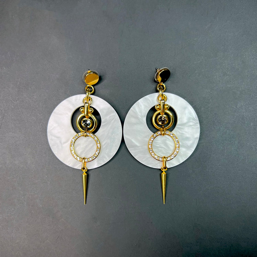 White and gold statement earrings with pearlized acrylic discs, crystal-studded rings, and gold spike drops – summer fashion jewelry