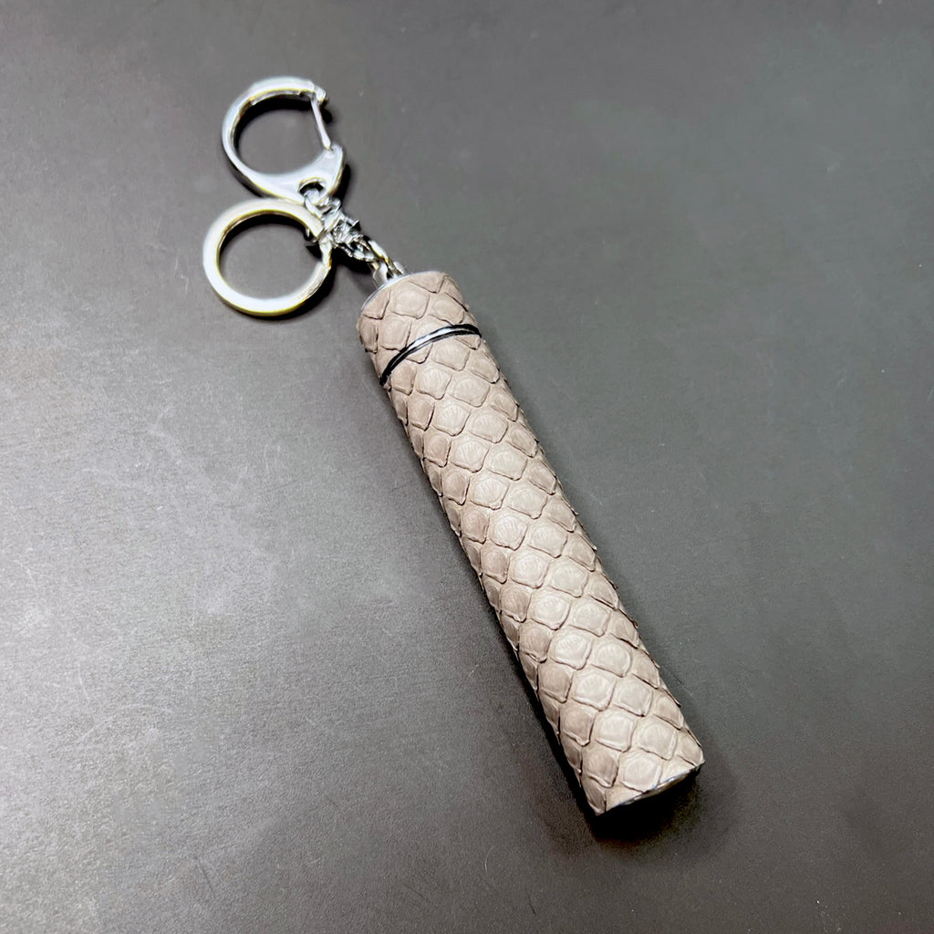 Luxury Storm Grey python wrapped pre-roll holder key charm laid flat on black background