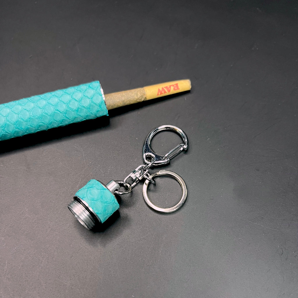 Python-wrapped Tiffany blue keychain with opened stash tube showing a RAW joint