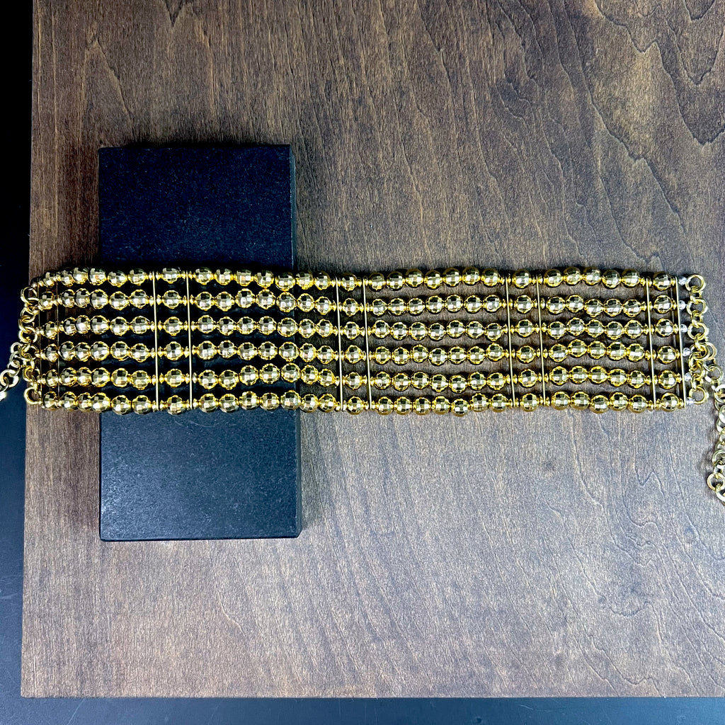 Flat lay of gold multi-row beaded choker with adjustable clasp – statement necklace for women
