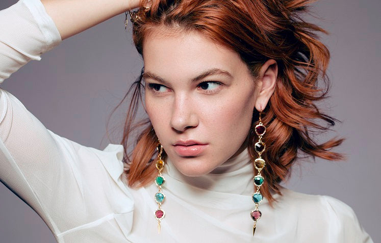 Model wearing long multicolor crystal earrings with gold accents – Laverne rainbow chandelier statement earrings