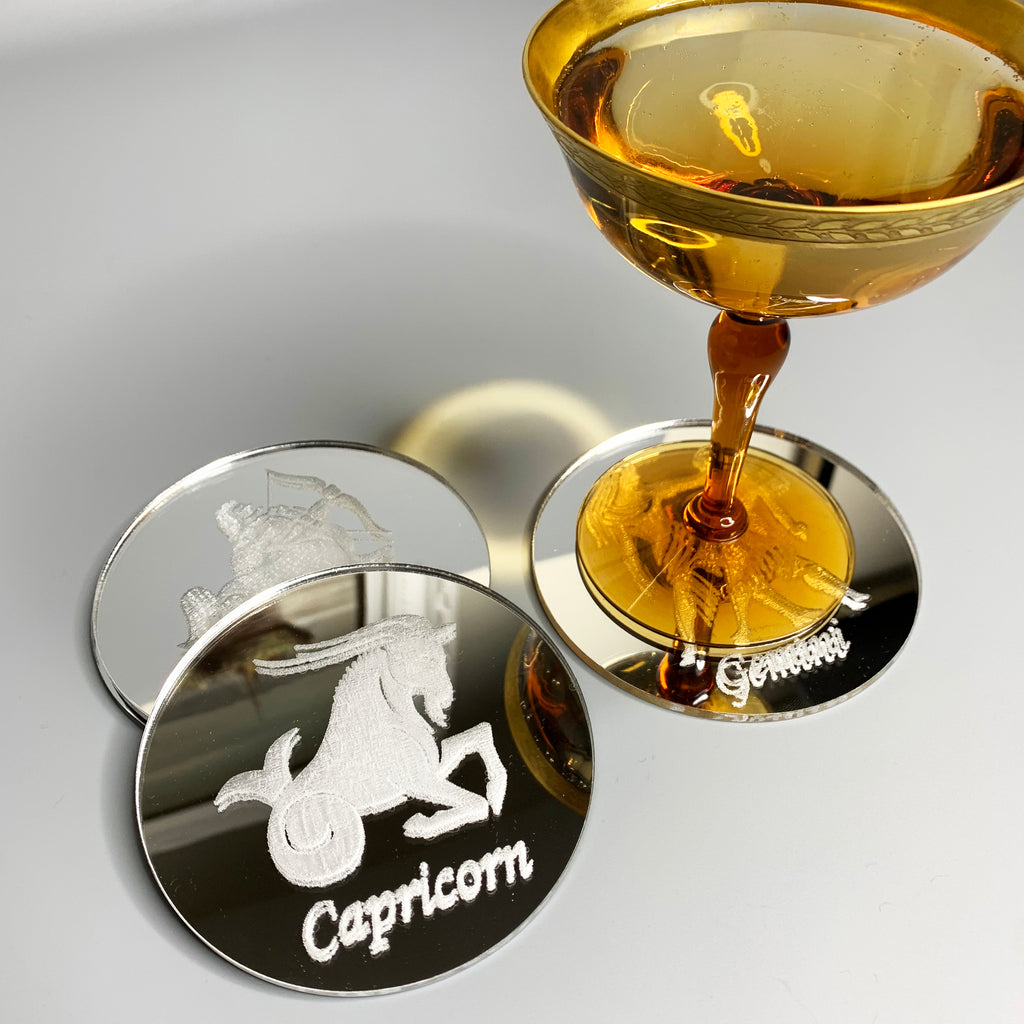 Round silver mirrored acrylic drink coaster engraved with the Capricorn zodiac symbol