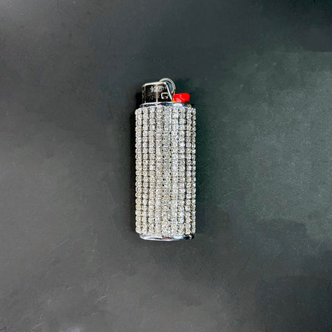 Luxury crystal-studded lighter case sparkling under light on black background.
