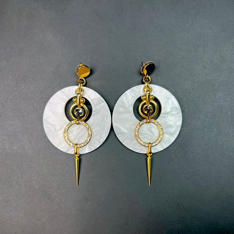 White and gold statement earrings with pearlized acrylic discs, crystal-studded rings, and gold spike drops – summer fashion jewelry