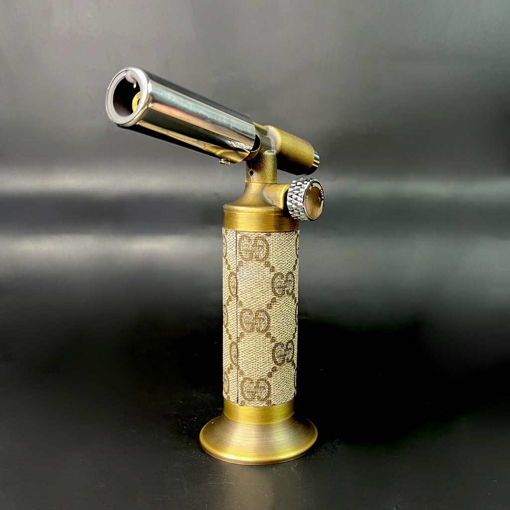 Angled view of vintage GG wrapped torch featuring adjustable knob and antique brass components.