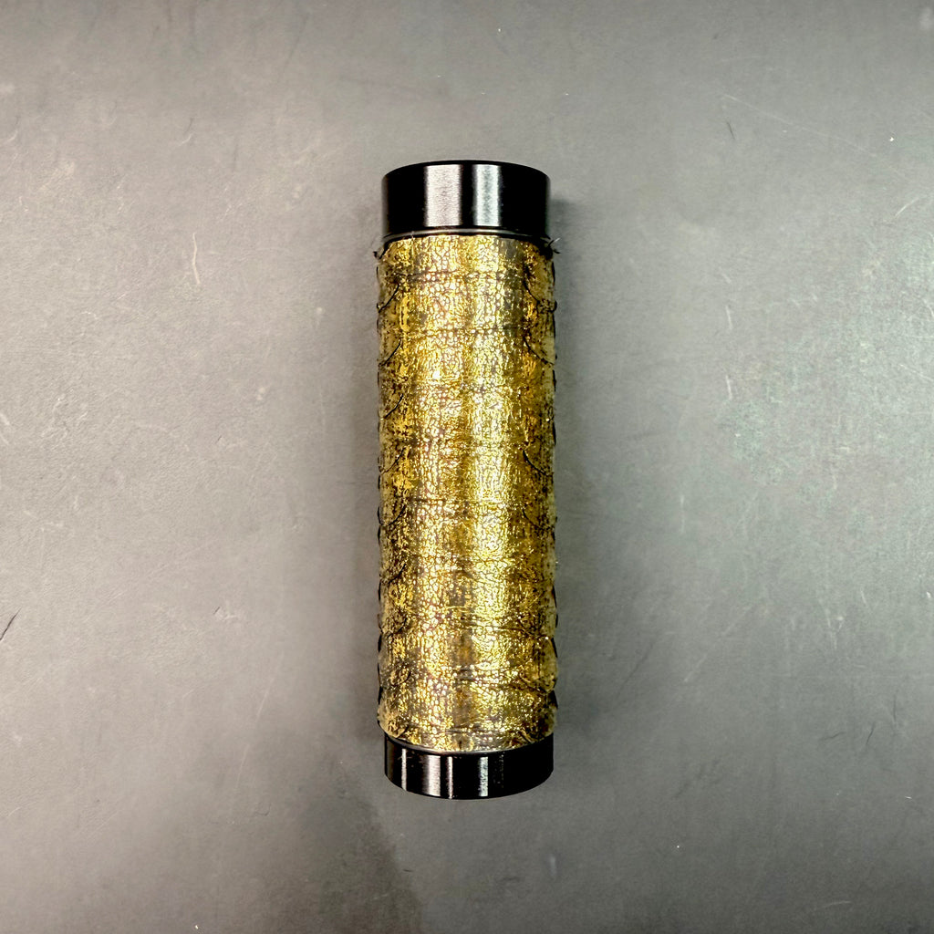 Close-up of the Metallic Gold Python Dugout fully assembled, showing the shimmering texture of the gold python leather and sleek black metal ends.