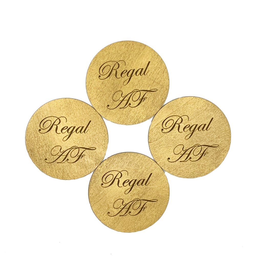 Round wood drink coasters coated in metallic gold and engraved with Regal AF