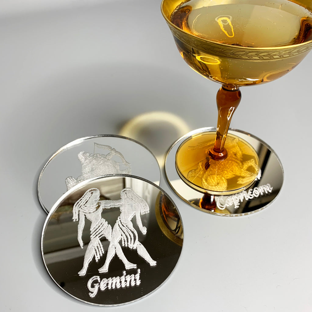 Round silver mirror acrylic drink coaster engraved with the Gemini zodiac sign